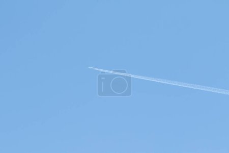 Téléchargez les photos : Haut dans le ciel bleu la trace d'un avion - en image libre de droit