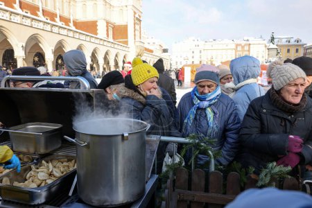 Foto de Cracovia, Polonia - 18 de diciembre de 2022: Nochebuena para pobres y sin hogar en la Plaza Principal de Cracovia. El grupo Kosciuszko prepara la víspera más grande al aire libre en Cracovia - Imagen libre de derechos