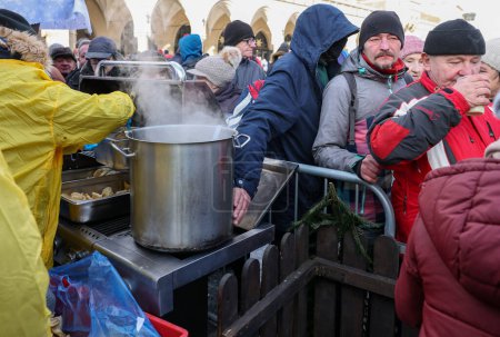 Foto de Cracovia, Polonia - 18 de diciembre de 2022: Nochebuena para pobres y sin hogar en la Plaza Principal de Cracovia. El grupo Kosciuszko prepara la víspera más grande al aire libre en Cracovia - Imagen libre de derechos