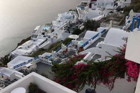 Foto de Imerovigli, Santorini, Grecia - 1 de julio de 2021: Casas encaladas con terrazas y piscinas y una hermosa vista en Imerovigli en la isla de Santorini, Grecia - Imagen libre de derechos