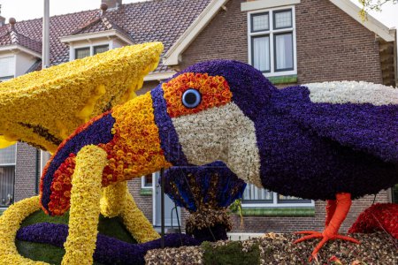 Téléchargez les photos : Noordwijkerhout, Pays-Bas - 21 avril 2023 : Perroquet composé de tulipes et jacinthes présenté avant le défilé de fleurs illuminé en soirée Bollenstreek à Noordwijkerhout - en image libre de droit