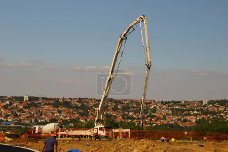 Photo for On a bright and sunny day, a towering crane stands against the deep blue sky, surrounded by a lush green landscape of grass and beach, beckoning adventurers to take a wild ride to new heights - Royalty Free Image