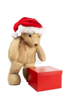 Photo for Teddy bear standing next to a gift package isolated on white background - Royalty Free Image