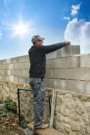 Foto de Albañiles construyendo nueva pared con ladrillo blanco - Imagen libre de derechos