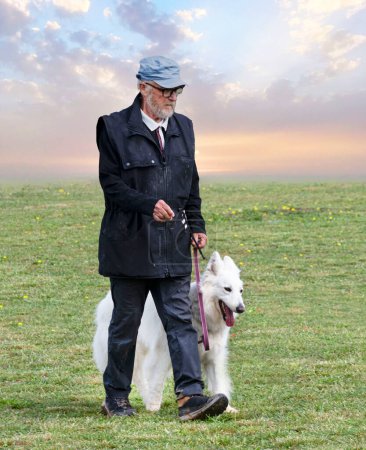 Foto de Perro pastor suizo blanco y propietario en una competencia de obediencia - Imagen libre de derechos