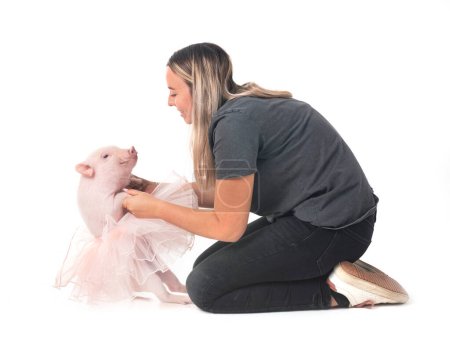 pink miniature pig and woman in front of white background