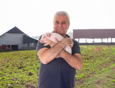 pink young pig and man in front of fields and farm