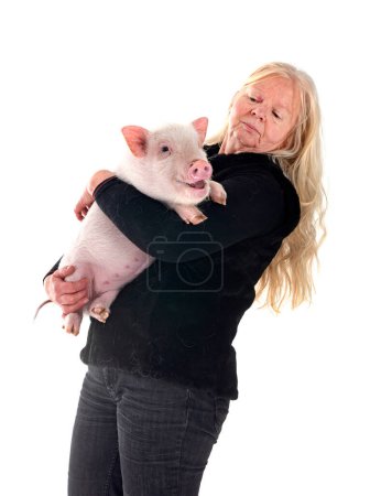 pink miniature pig and woman in front of white background