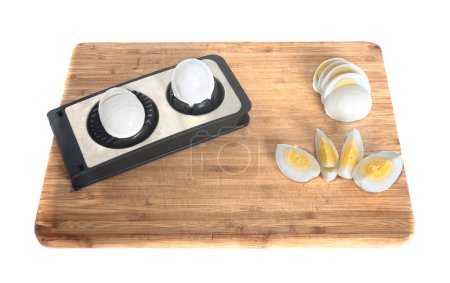Egg slicer in front of white background