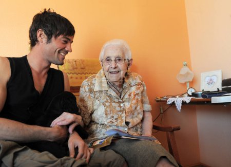 foto de una vieja abuela en su dormitorio y su nieto