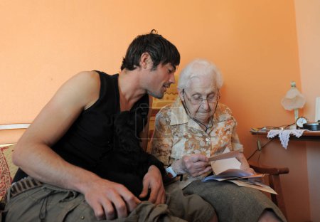 foto de una vieja abuela en su dormitorio y su nieto