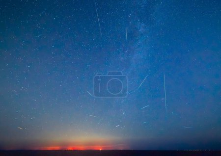 Téléchargez les photos : Voie lactée et douche Perséide 2023 au-dessus de la Sicile - tourné de Malte. Beau ciel nocturne avec la Voie lactée et les lumières côtières de la Sicile vu de Malte - en image libre de droit