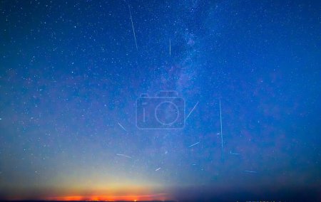 Téléchargez les photos : Voie lactée et douche Perséide 2023 au-dessus de la Sicile - tourné de Malte. Beau ciel nocturne avec la Voie lactée et les lumières côtières de la Sicile vu de Malte - en image libre de droit