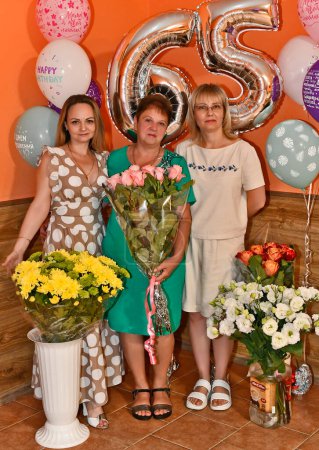 Foto de En el aniversario de una mujer adulta de 65 años, toda la familia extendida celebra. - Imagen libre de derechos