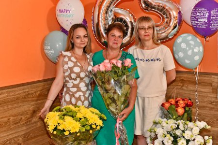Foto de En el aniversario de una mujer adulta de 65 años, toda la familia extendida celebra. - Imagen libre de derechos