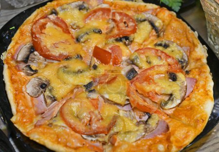 Téléchargez les photos : La pizza est un plat italien traditionnel, à l'origine sous la forme d'un pain plat rond de levure cuit avec une sauce tomate remplissage sur le dessus. - en image libre de droit