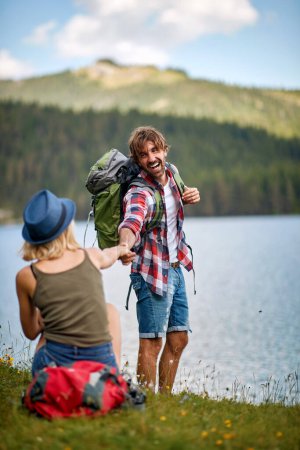 Photo for Young adult caucasian couple having fun by the lake in the wilderness - Royalty Free Image