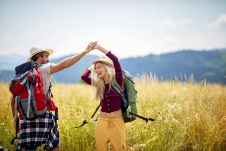 Photo for A young couple having a good time while hiking on a beautiful sunny day in the nature. Hiking, relationship, nature, activity - Royalty Free Image