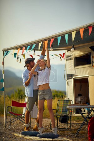 Photo for Young man and woman  preparing party by car outdoors - Royalty Free Image