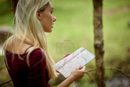 Téléchargez les photos : Jeune femme caucasienne regardant dans une carte pour les directions - en image libre de droit