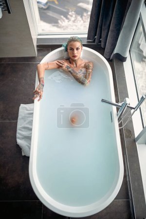 Téléchargez les photos : Vue du dessus de la femme dans la baignoire dans la salle de bain - en image libre de droit