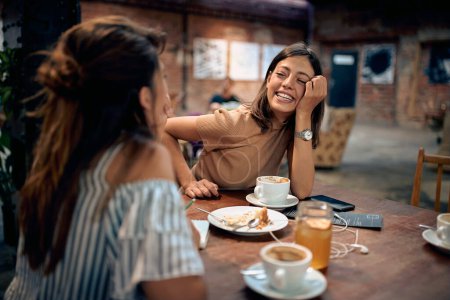 Photo for Young beautiful women having coffee and feeling joyful in cafe. Togetherness, fun, coffee break concept. - Royalty Free Image