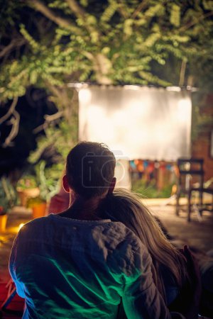 Téléchargez les photos : Couple romantique profiter ensemble film en plein air nuit - en image libre de droit