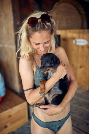 Foto de Chica y perro. Una mujer sostiene a un perrito y da palmaditas. - Imagen libre de derechos