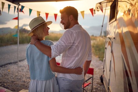 Photo for Cheerful  young man and woman Near Modern Camper Van In Camping at  evenin - Royalty Free Image