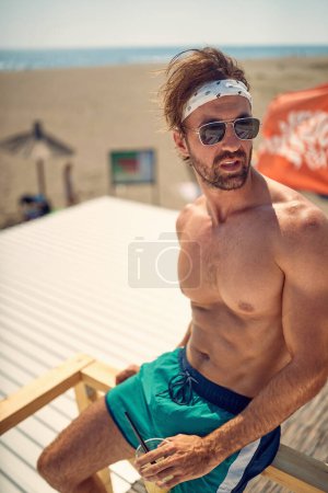 Photo for Shirtless handsome caucasian male posing alone on the beach - Royalty Free Image