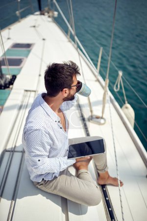 Photo for Casual businessman working on the yacht on a sunny day - Royalty Free Image