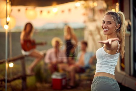 Photo for A young sexy girl at the campsite is posing for a photo during a vacation in the nature with her friends on a beautiful sunset. Vacation, friendship, camping, nature - Royalty Free Image