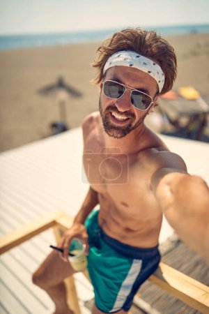 Foto de Sin camisa caliente caucásico macho posando solo en la playa - Imagen libre de derechos