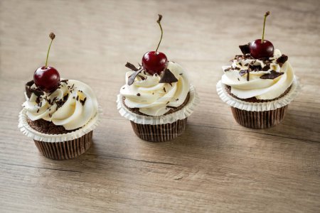 Foto de Cupcake decorado con crema de vainilla cremosa y cherr postre rojo - Imagen libre de derechos
