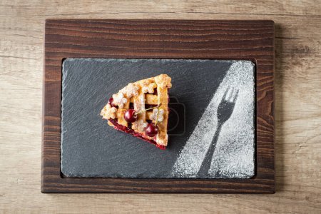Photo for Slice cherry pie on dark plate sprinkle powdered sugar top vie - Royalty Free Image