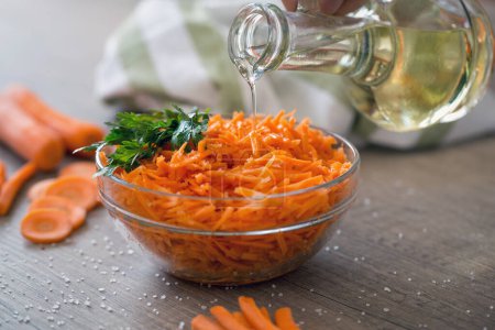 Öl auf vegetarischen Salat mit rohem, frischem Carro gießen