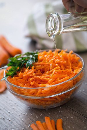 Photo for Vegetarian salad with raw fresh carrot pouring oi - Royalty Free Image