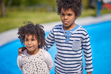 Photo for The sunny day provides a perfect backdrop as these adorable toddler siblings enjoy poolside together. - Royalty Free Image