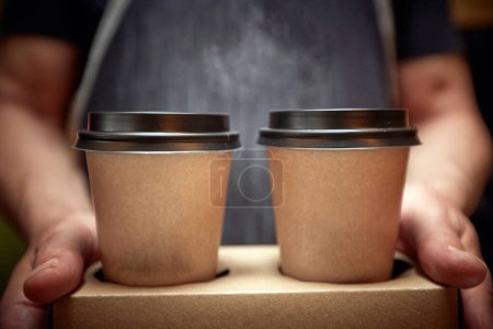 Foto de Detalle del hombre caucásico sosteniendo dos cafés en taza de cartón, mostrando, ofreciendo - Imagen libre de derechos