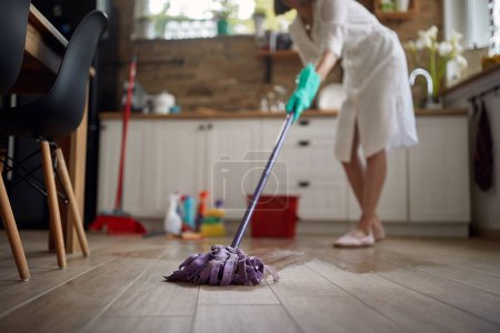 Photo for Woman who commands attention with her skillful mastery of the mop. With effortless grace, she glides across the floor, navigating every nook and cranny with precision. - Royalty Free Image