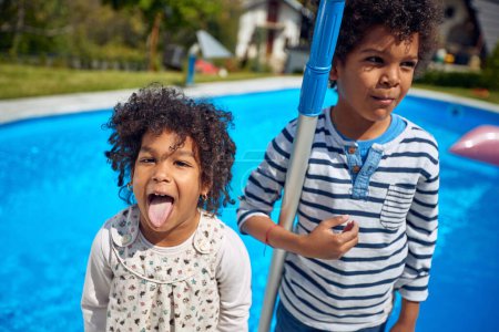 Photo for Afro-American boy and girl take center stage, radiating happiness. The girl, with a mischievous grin, playfully sticks out her tongue, adding a touch of spontaneity to the moment. - Royalty Free Image
