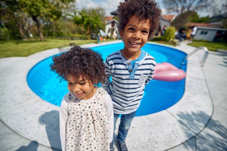 Photo for Afro-American siblings as they enjoy a playful moment by the poolside. With a shared sense of humor, their joyous laughter fills the air, echoing the deep bond they share. - Royalty Free Image
