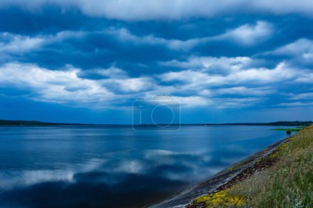 Photo for Thunderstorm approaching the lake. Black clouds hanging over the water - Royalty Free Image