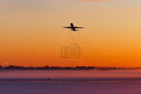 The plane takes off at dawn in heavy fog in winter