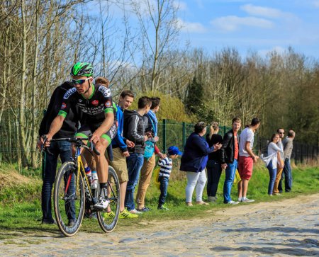 Photo for Carrefour de l'Arbre, France - April 12,2015: The French cyclist, Pierre-Luc Perichon of Team Bretagne - Seche Environnement, riding in the famous sector Careffour de l'Arbre during Paris-Roubaix race in 2015. - Royalty Free Image