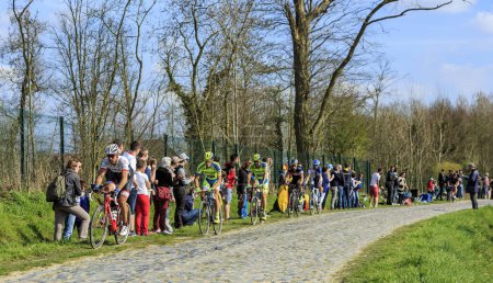 Téléchargez les photos : Carrefour de l'Arbre, France - 12 avril 2015 : Image d'un groupe de quatre cyclistes du célèbre secteur Careffour de l'Arbre lors de la course Paris-Roubaix 2015. - en image libre de droit