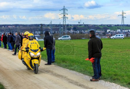 Téléchargez les photos : Vendome,France- March 7,2016: The official yellow bike of LCL rides on a dirty road,Tertre de la Motte, in Vendome, during the first stage of Paris-Nice 2016. - en image libre de droit