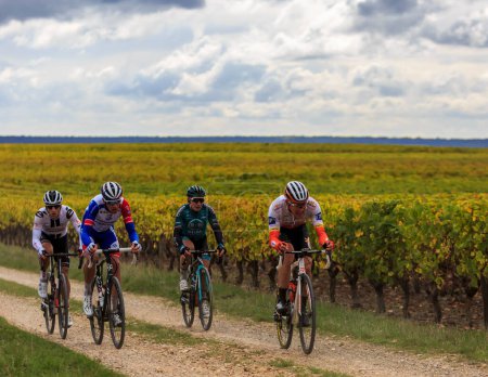 Téléchargez les photos : Noizay, France - October 11, 2020: Image of a group of four cyclists riding in the vineyards during Paris-Tours 2020 - en image libre de droit