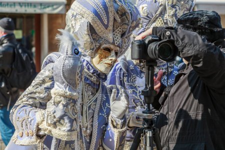 Foto de Venecia, Italia- 18 de febrero de 2012: Imagen de una persona vestida con un disfraz veneciano de belleza revisando una foto en la cámara durante los días del Carnaval de Venecia. - Imagen libre de derechos