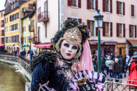 Photo for Annecy, France- February 23, 2013: Environmental portrait of an unidentified person disguised in a beautiful costume in Annecy, France, during a Venetian Carnival, which is held yearly, to celebrate the beauty of the real Venice - Royalty Free Image